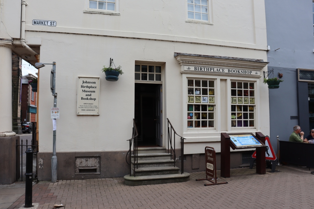 Entrance to a building with a bookshop on one side. A notice reads "Johnson Birthplace Museum and Bookshop"